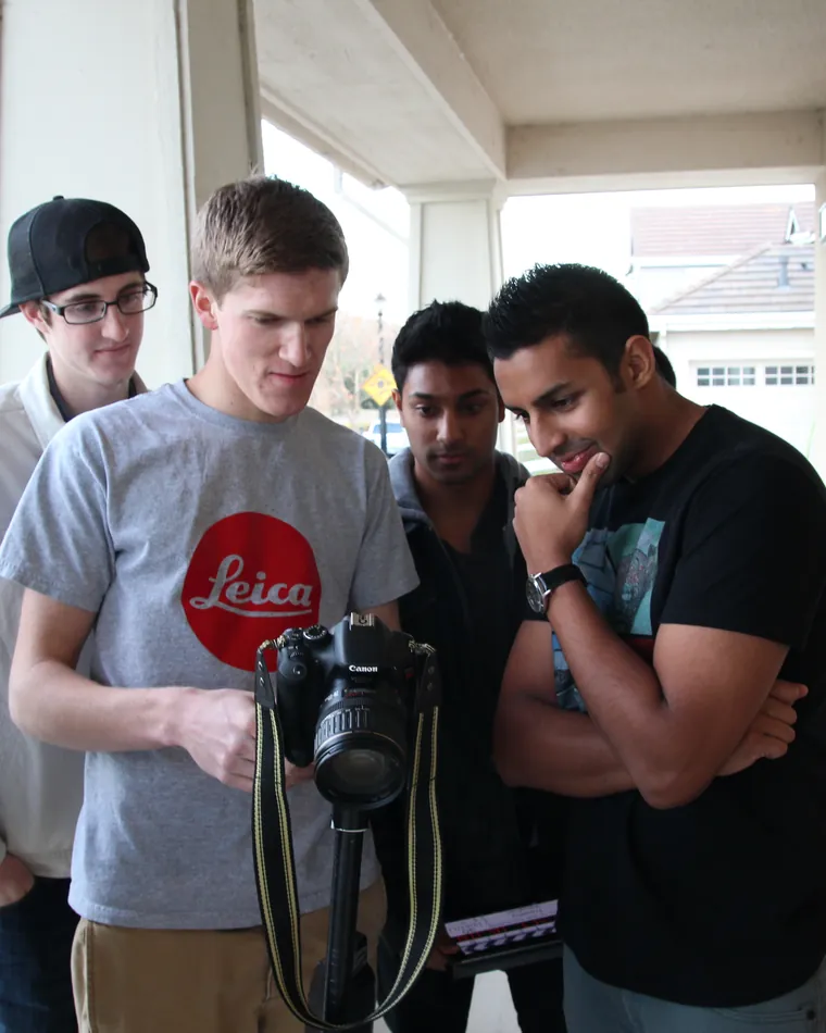 The first crew huddled around a camera
